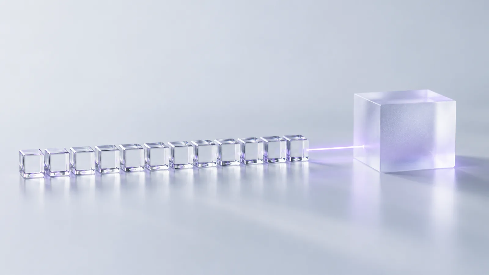 Dodici piccoli cubi di vetro allineati accanto a un unico blocco di cristallo smerigliato grande quanto tutti insieme
